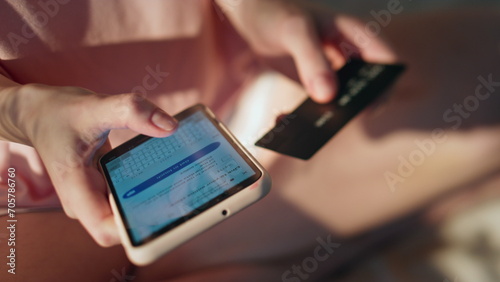 Hands making online shopping holding smartphone closeup. Girl insert debit card