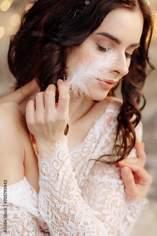 Close-up portrait of a beautiful Caucasian woman with long wavy brunette hair wearing a beige dress and posing against the background of Christmas tree lights in a dark interior. Close-up portrait of a beautiful Caucasian woman with long wavy brunette hair wearing a beige dress and posing against the background of Christmas tree lights in a dark interior.