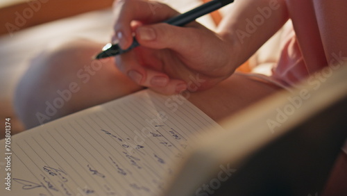 Hand making handwriting notes closeup. Girl holding pen planning day in morning. photo
