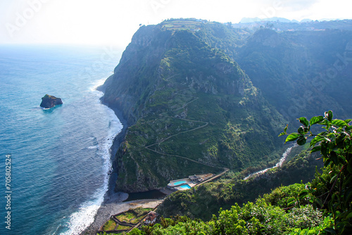 Winding road leading down to a bathing complex with outdoor swimming pool in Sao Jorge on the north coast of Madeira island (Portugal) in the Atlantic Ocean
