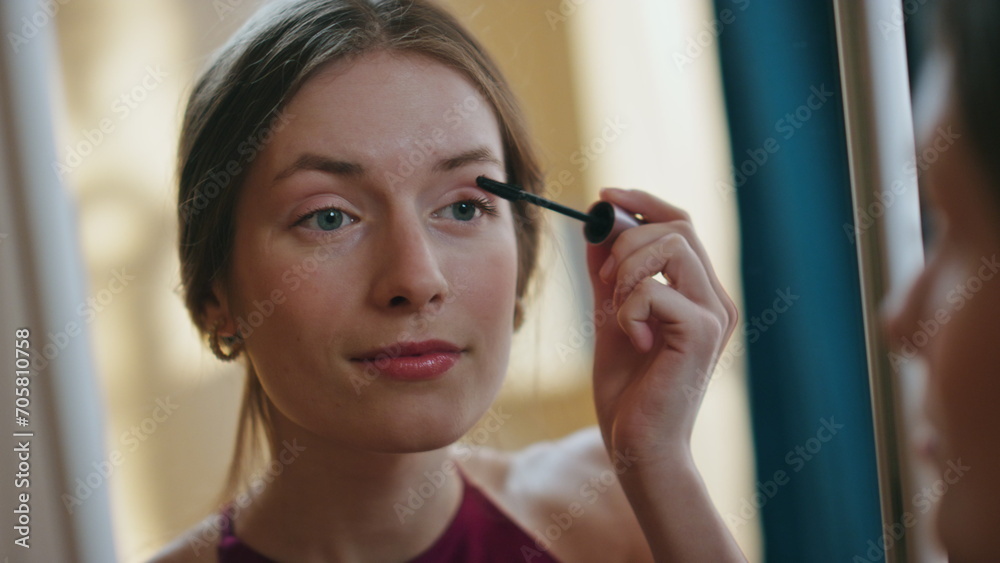 Closeup girl using mascara applying on eyelashes. Woman reflection in mirror