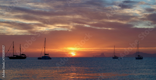 Wonderful sunset close to Ses Illetes beach in Formentera, Balearic Islands, Spain (no visible brand names or logos, only national flags on sailboats). © nachosuko