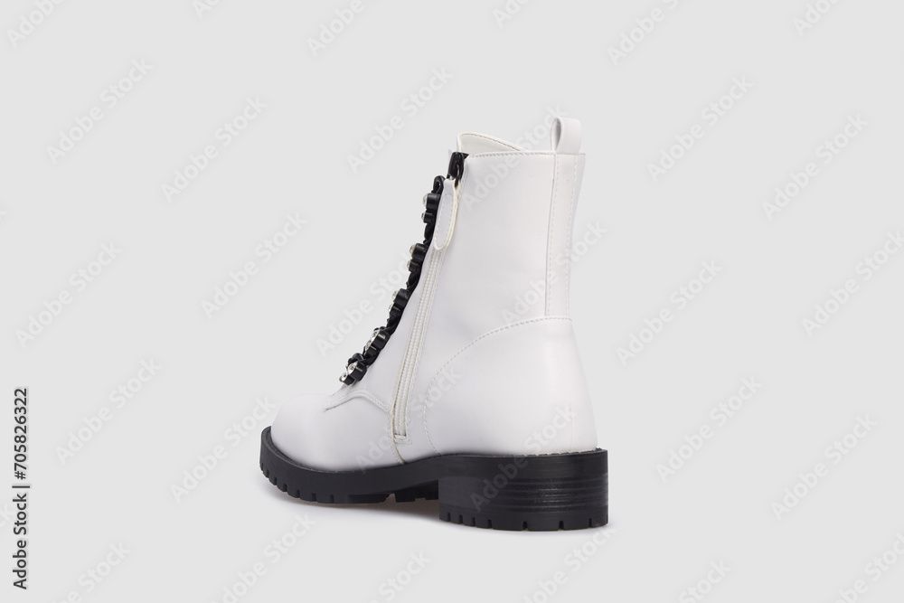 Behind view on white women's fashion Combat boot, spring autumn shoe isolated on white background. Female leather luxury casual footwear with rough black sole. Single