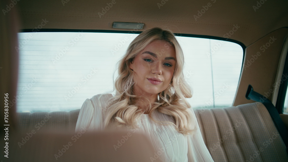 Gorgeous blonde sitting automobile looking camera close up. Girl relaxing in car
