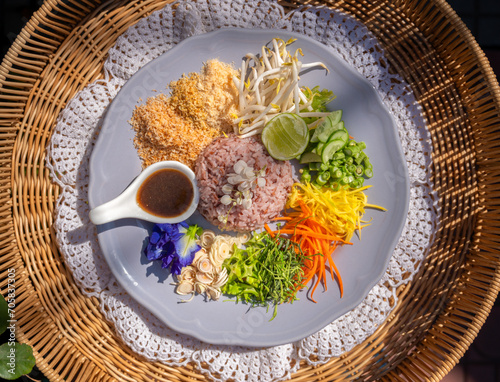 Steamed rice with various herbs and vegetables mixed with Budu sauce. Thai Southern Spicy Rice Salad with Vegetables with  Budu Thai southern styled fish sauce.