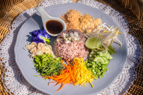 Steamed rice with various herbs and vegetables mixed with Budu sauce. Thai Southern Spicy Rice Salad with Vegetables with  Budu Thai southern styled fish sauce.