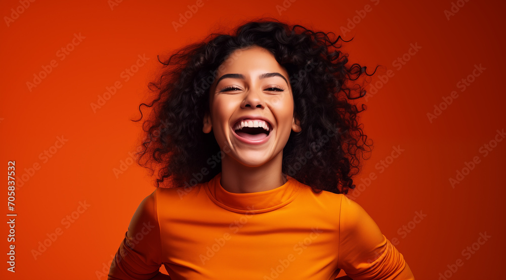 Jeune femme brune, heureuse, souriante, arrière-plan orange
