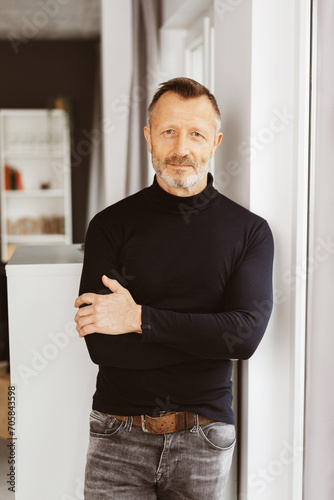 Free Download Confident Bestager Man in Stylish Black Turtleneck, Arms Crossed, Gazing into the Camera with Modern Elegance - GFXLoad