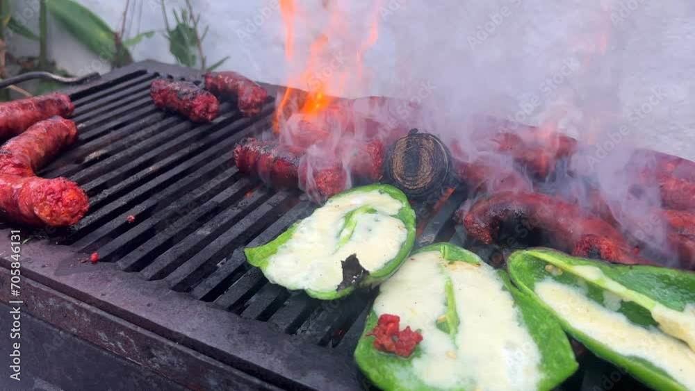 Chorizo Carne asada en asador típico mexicano con chiles verdes poblanos con queso derretido asando comida en un día caluroso en México al calor de las brasas