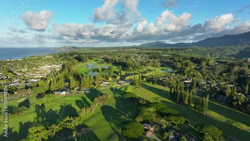 Aerial Kauai Princeville golf resorts ocean mountain afternoon 1. Expensive luxury homes, resort, condominium and golf club near coast. Recreation and tourism. Economy tourism. Warm tropical climate. photo