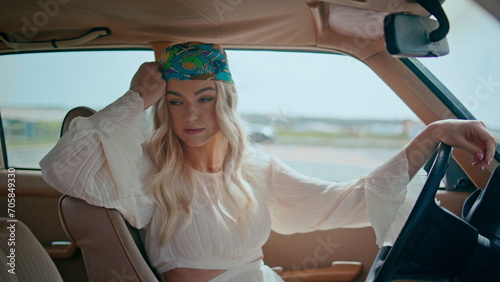 Woman sitting comfortable automobile in bandanna closeup. Model posing retro car photo