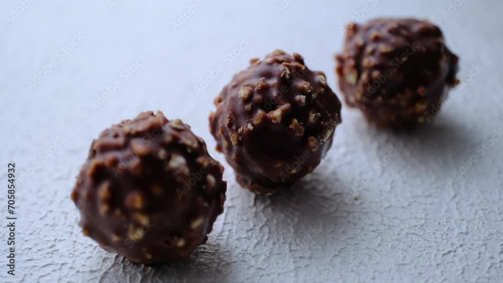 Milk chocolate with hazelnuts in round shape on white background Milk chocolate with hazelnuts in round shape on white background