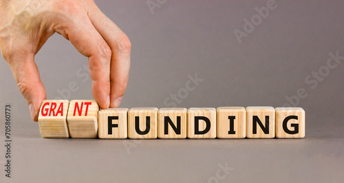 Grant funding symbol. Concept words Grant funding on beautiful wooden blocks. Beautiful grey table grey background. Businessman hand. Business and grant funding concept. Copy space. photo
