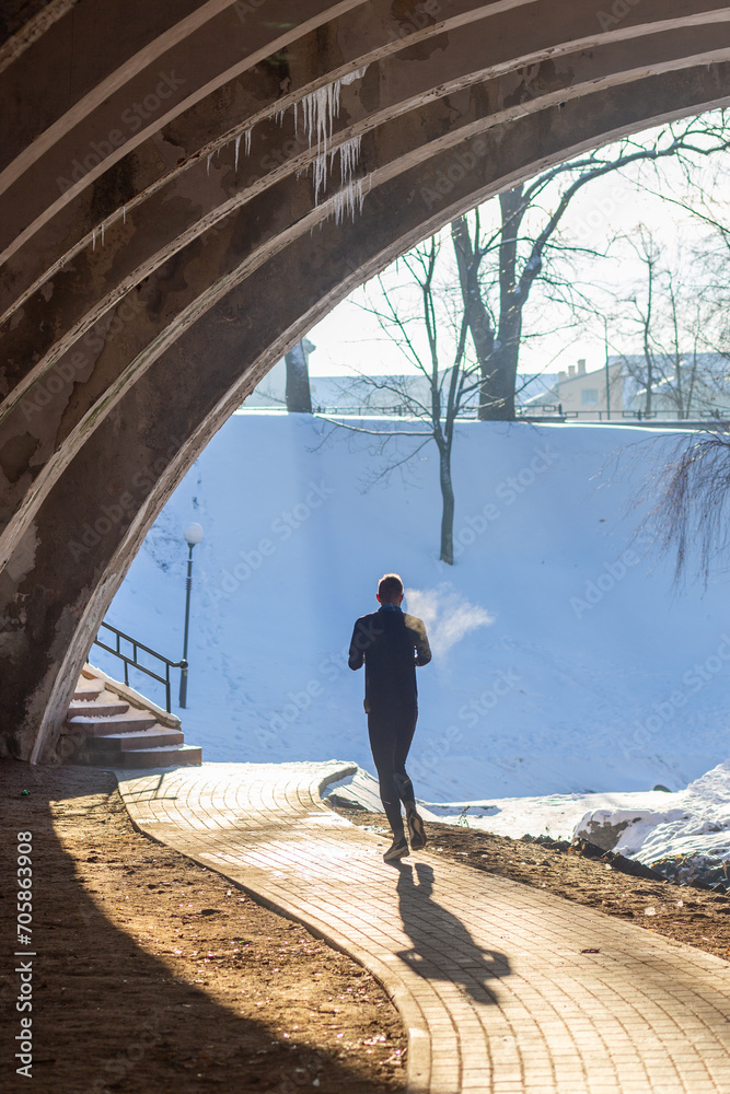 Young man participates in winter orienteering training in urban conditions.