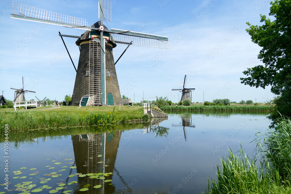 Beautiful windmills mirroring in canal, famous historic tourist landmark in Kinderdijk, Rotterdam, Netherlands