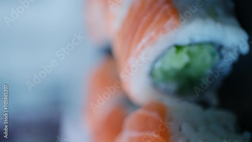California roll sushi on a 360 degree rotating table on a black background,vertical video photo