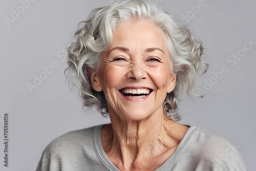 a closeup photo portrait of a beautiful elderly senior model woman with grey hair laughing and smiling with clean teeth. isolated on white background high quality image  photo