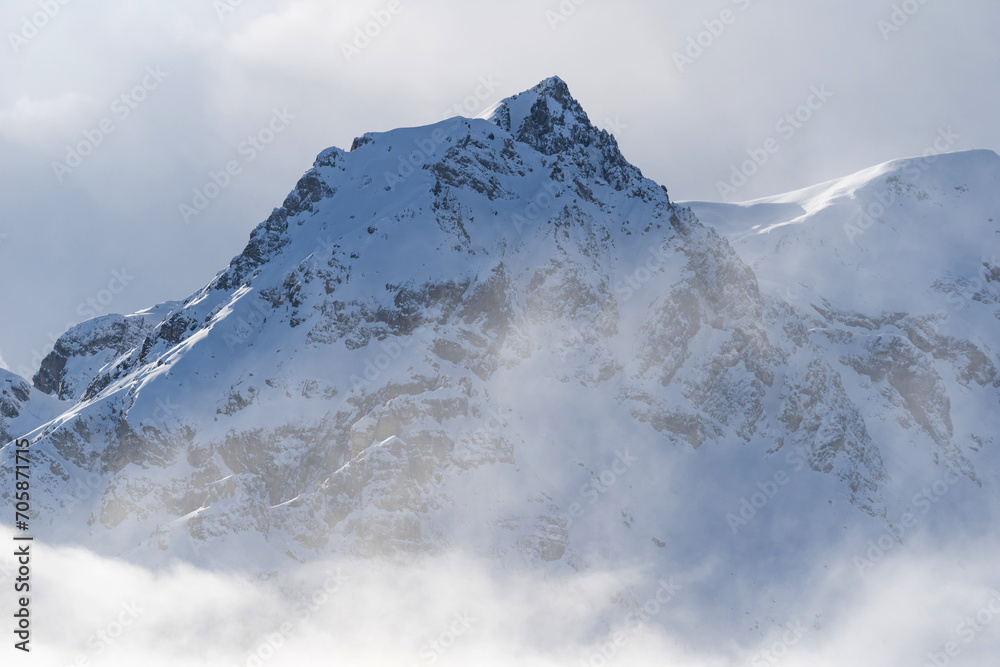 Obraz premium Mountain covered with snow and fog. Alpine landscape in Italy, Europe. Snow-capped mountains