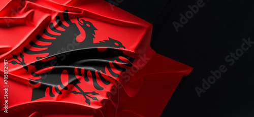 Flag of Albania. Fabric textured Albania flag isolated on dark background. 3D illustration