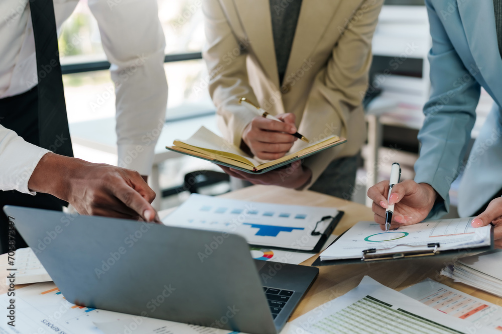 Business representatives meeting pointing on laptop computer. Business team discussing investment plan using data on laptop. Business representatives meeting pointing on laptop computer. Business team discussing investment plan using data on laptop.