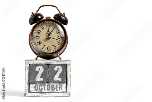 October 22 on wooden calendar with alarm clock white background. photo