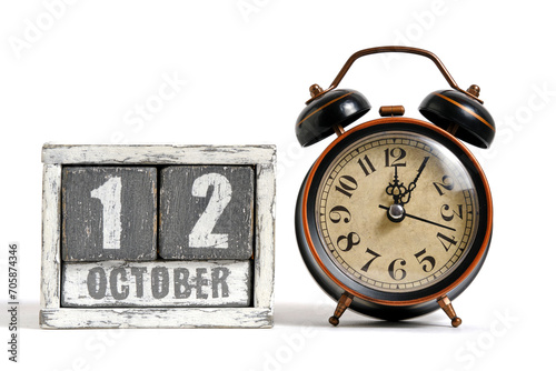 October 12 on wooden calendar with alarm clock white background. photo