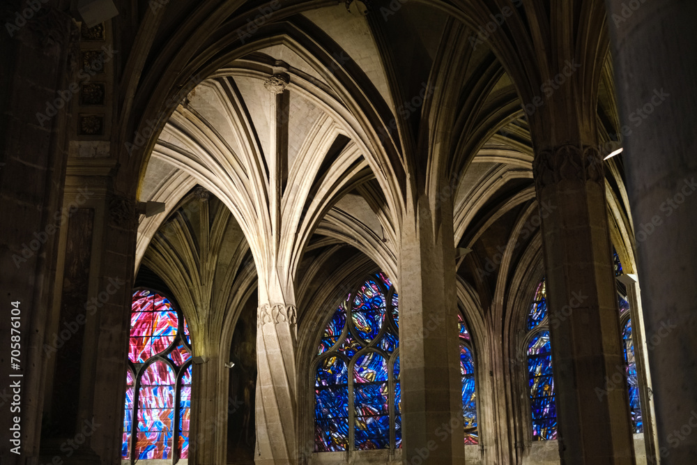 Beautiful stained glass windows with colorful biblical scenes, inside a Parisian church.