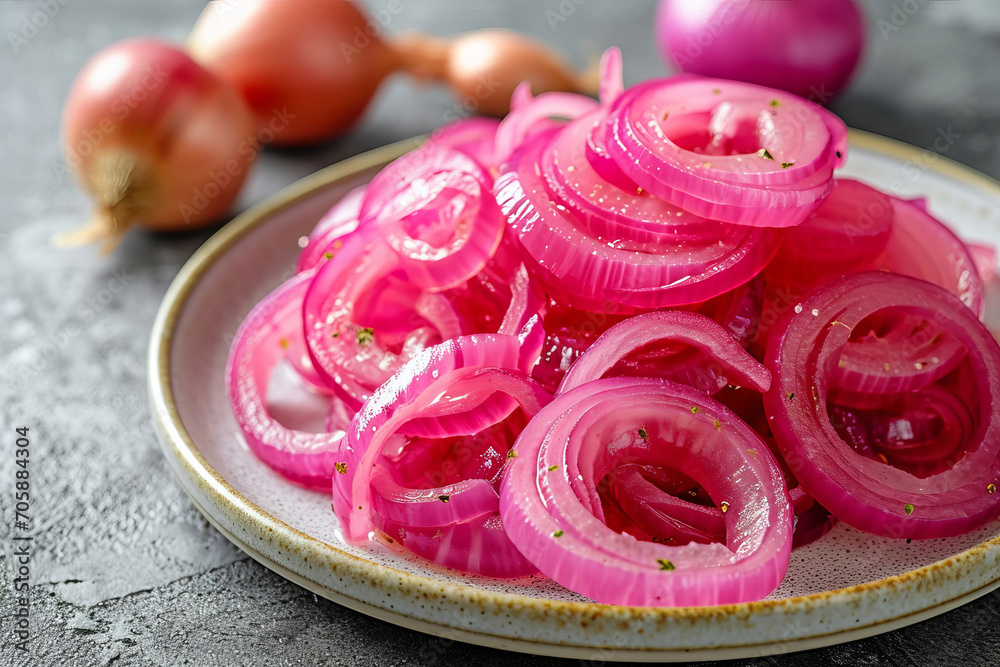 Red pickled onion rings lie on a gray background. Red pickled onion rings lie on a gray background.