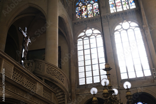 Paris, France - December 31, 2023: Interior of a church, with sun rays illuminating the Christian cross.