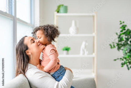 Mother with little daughter at home sofa
