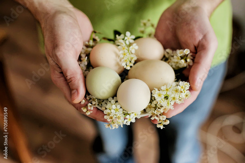 Floral Elegance: Embracing Spring's Harvest.  Easter eggs decorted with flowers. Man hold chicken eggs in his arms close-up