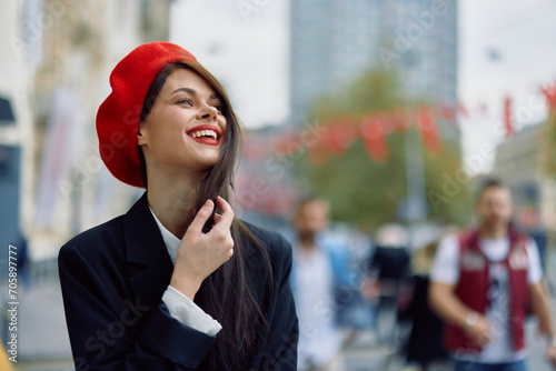 A beautiful smile woman with teeth walks in the city against the backdrop of office buildings, stylish fashionable vintage clothes and makeup, autumn walk, travel.