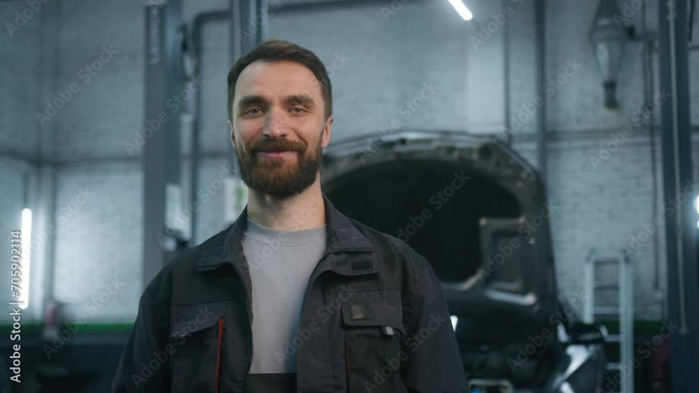 Portrait of smiling auto mechanic technical employee in work uniform looking camera at car repair service station happy male specialist Caucasian bearded man smiling concept of automobile maintenance Portrait of smiling auto mechanic technical employee in work uniform looking camera at car repair service station happy male specialist Caucasian bearded man smiling concept of automobile maintenance