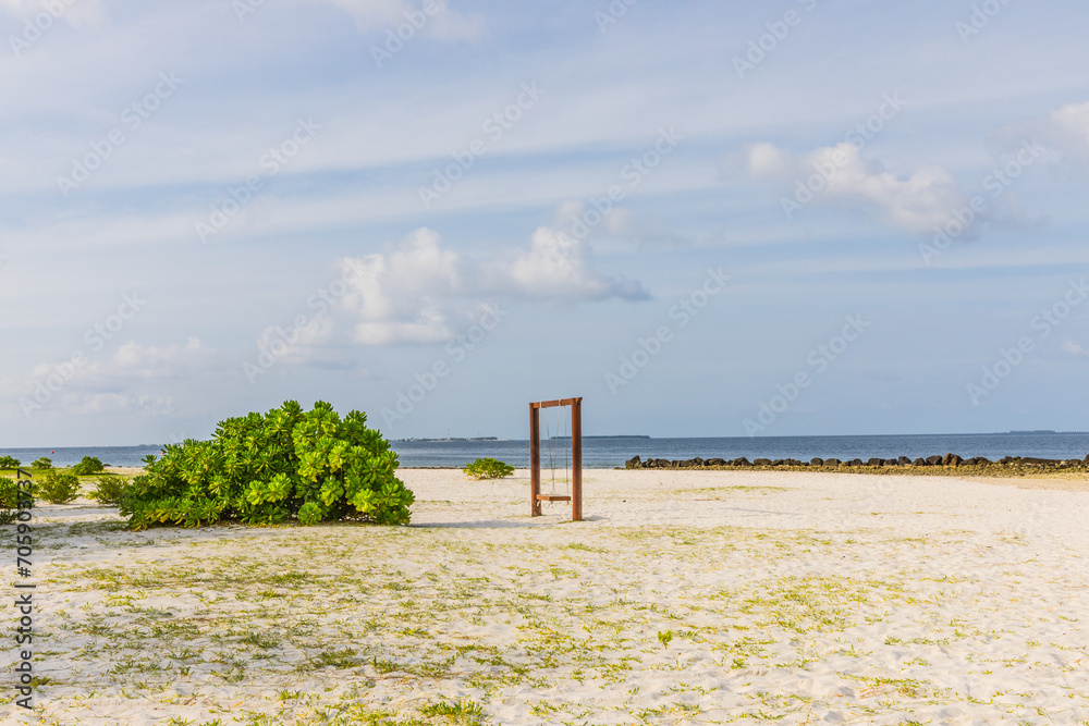 wooden swing on a white sand beach on the Indian Ocean in the Maldives