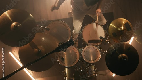 Top view male drummer hits the drums. Drummer rehearsing on drums in a dark studio. Music or song recording photo