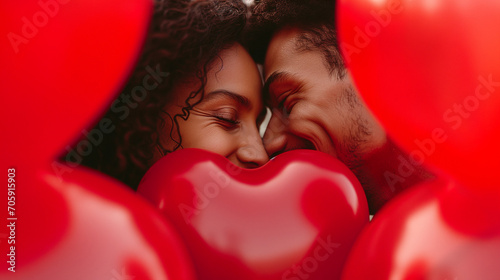 Young Couple Flirting and Kissing Behind Heart Shaped Balloon photo