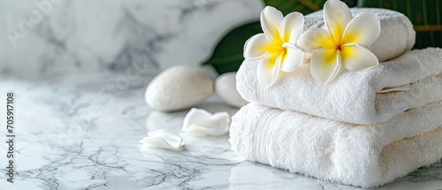 A soothing spa arrangement with soft white towels complemented by plumeria flowers. Spa salon concept