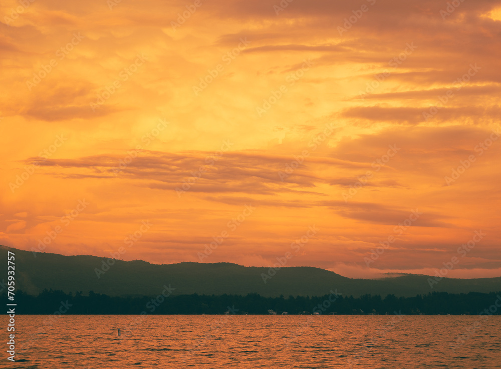 Photo of panorama sunset in the mountain on background with a peaceful lake. landscape of Idyllic sunset.