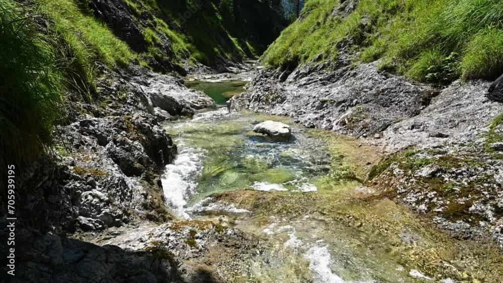 A stoney mountain stream in summer with a butterly passing (slow motion, lens flares) A stoney mountain stream in summer with a butterly passing (slow motion, lens flares)