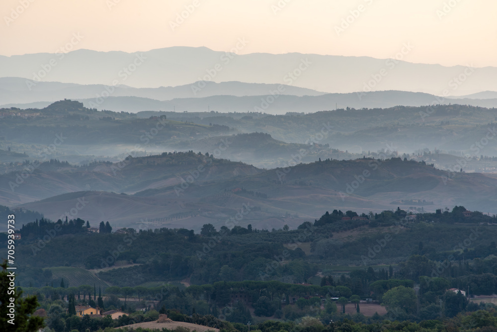 Typical Tuscan landscape with hills and cypresses in the very early morning near Montaione