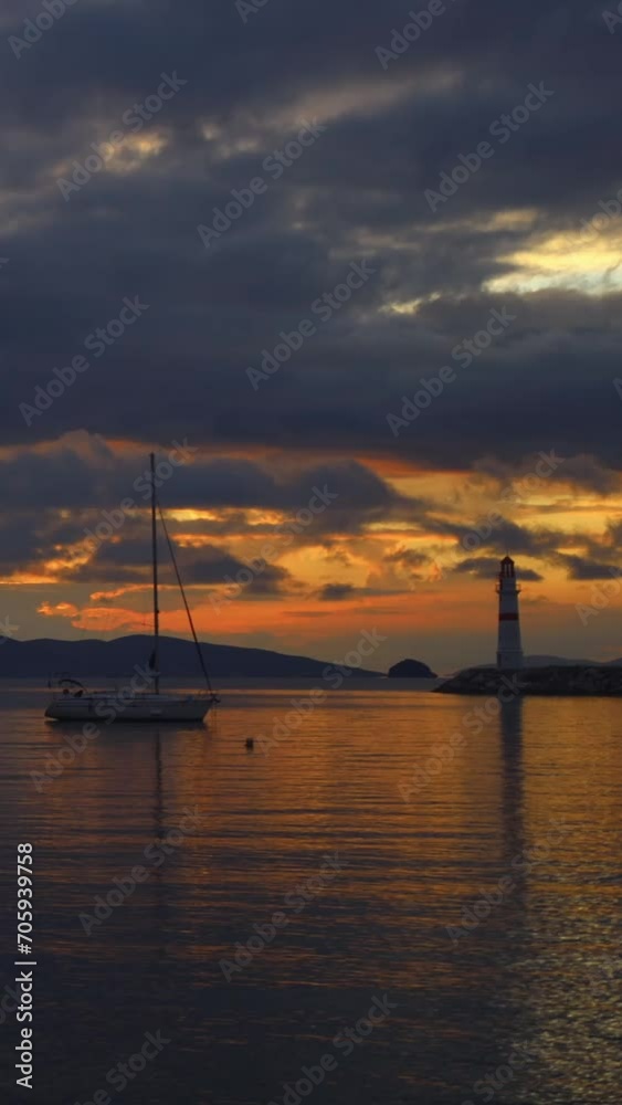 Seascape at sunset. Lighthouse on the coast. Seaside town of Turgutreis and spectacular sunset. Vertical video for social media.	
