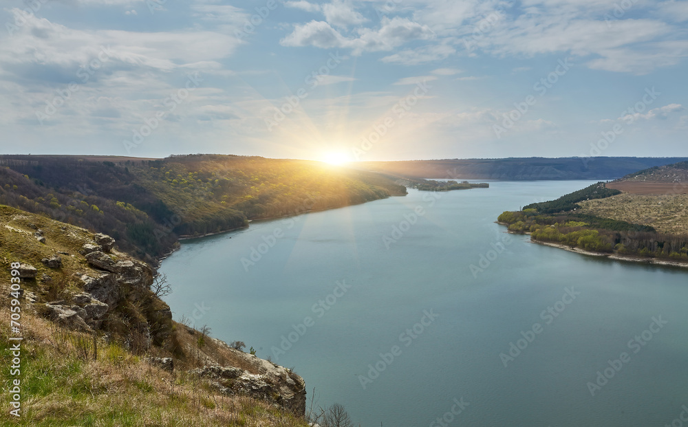 banks of a large river. Bakota, Dniester river, Ukraine. Smooth calm water panoramic landscape. High banks, green hills. Summer day in Eastern Europe.