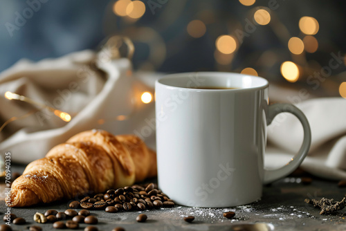 a coffee cup and croissant on a table