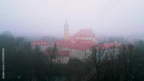 Aerial shot of the church in Lubomierz, in winter in very thick fog.