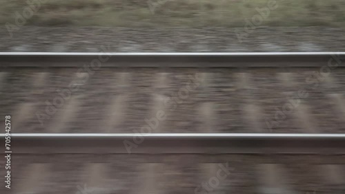 Rails on railway is blurred horizontally in motion.