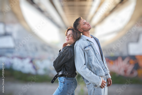 fashionable and youthful couple exudes style and love while striking poses on the city streets.
