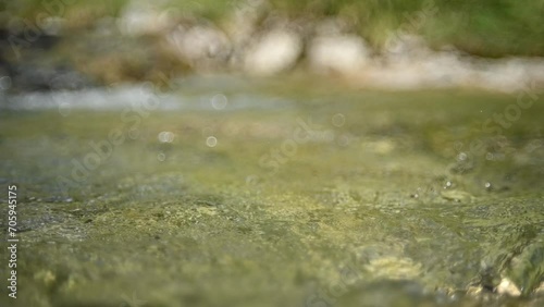 Bokeh of water from a mountain stream flowing in the evening (slow motion) photo