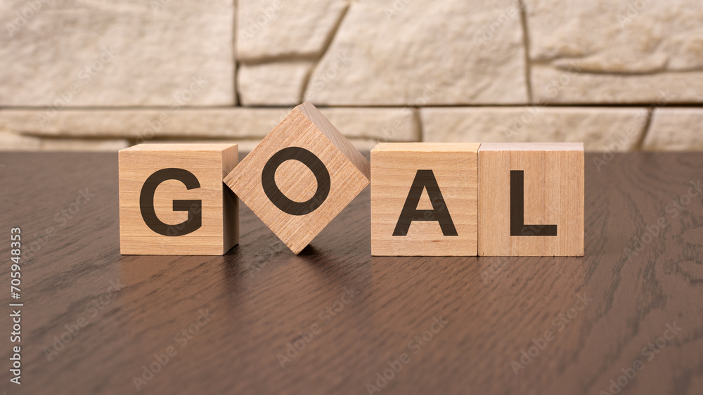 Fototapeta premium word GOAL block wood on wooden table background. GOAL business concept.