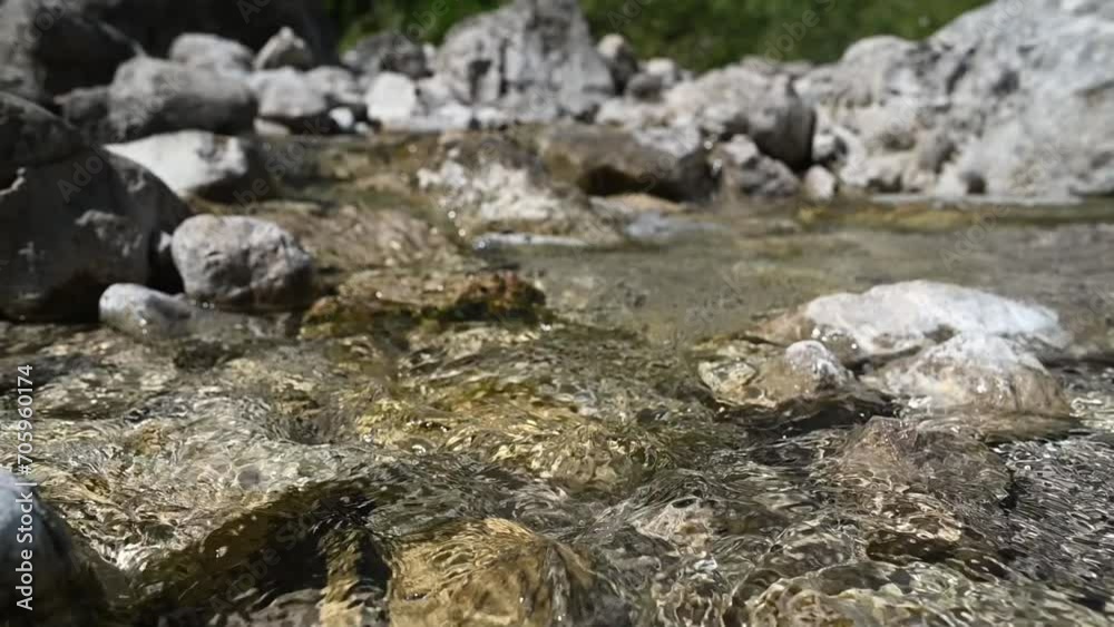 Closeup of water from a mountain stream flowing over stones (slow motion) Closeup of water from a mountain stream flowing over stones (slow motion)