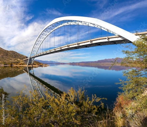Roosevelt Bridge Arch Ellipse Reflected in Apache Trail Lake Calm Water.  Scenic Superstition Mountains Landscape Angle View  Arizona Southwest US